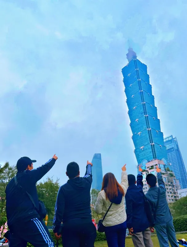 Friends pointing up at Taipei 101